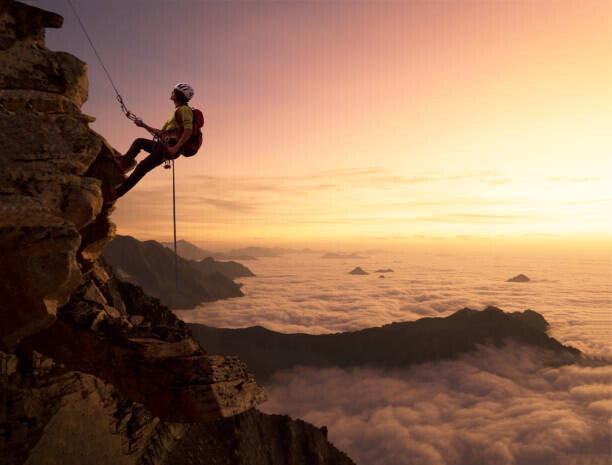 Leinwand Poster, Bilder Climber on a rocky wall over clouds, Buena Vista Images, 90 × 70 cm