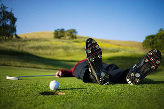 Leinwand Poster, Bilder Golfer lying on green, ball on edge of hole, Joe McBride, 90 × 60 cm